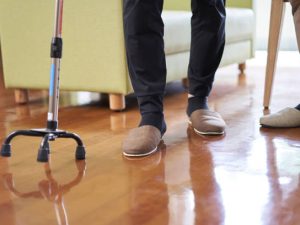 Elderly people and caregivers walking with a quadruped cane